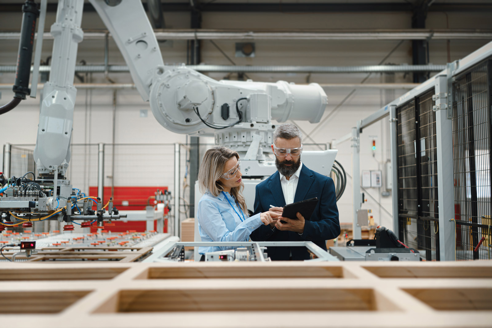 business woman and man standing on manufacturing floor